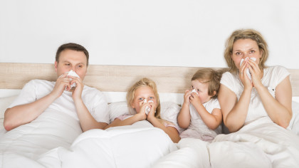 Sick Family Lying In Bed At Home